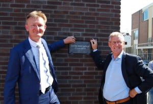 Wethouder Johan van Buuren (links) en directeur-bestuurder Ben Pluimer van HW Wonen plaatsten de plaquette in de gevel van de woningen aan de Nobelstraat.