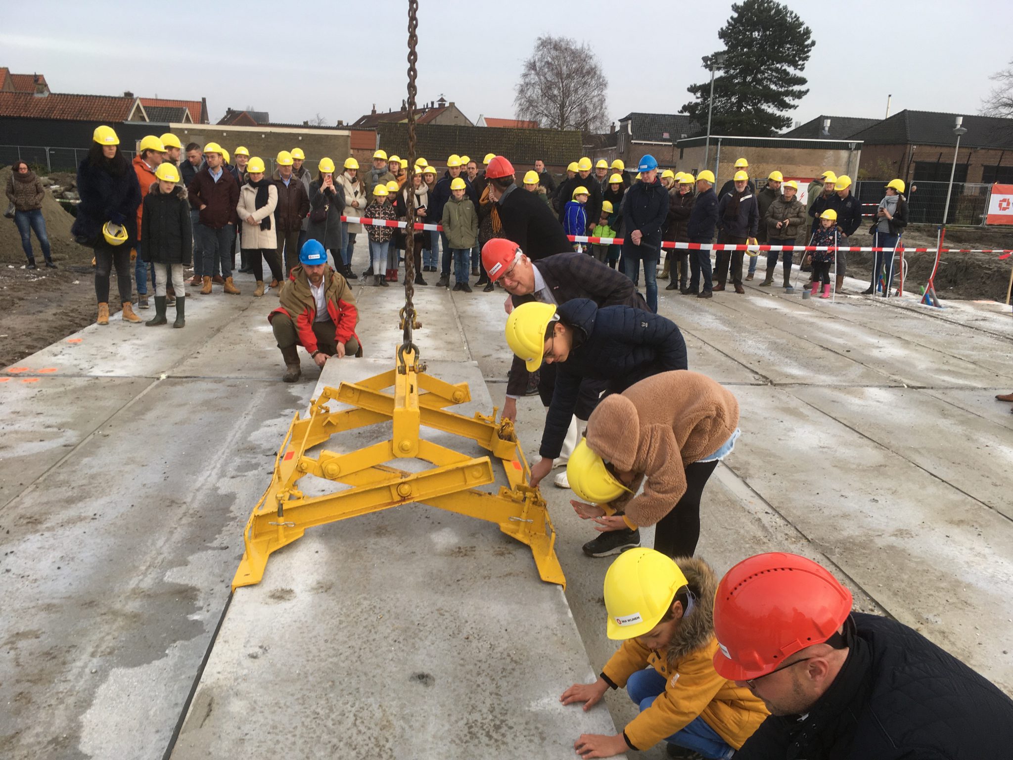 Wethouder Piet van Leenen en directeur Arjan van Meijeren van projectontwikkelaar Van Wijnen legden de eerste vloerplaat op de fundering. - Foto Gemeente Hoeksche Waard