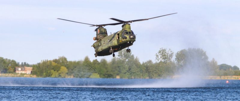 4 historische vliegtuigen, 2 Defensiehelikopters en vliegtuig tijdens bevrijdingsdag met banner boven Hoeksche Waard
