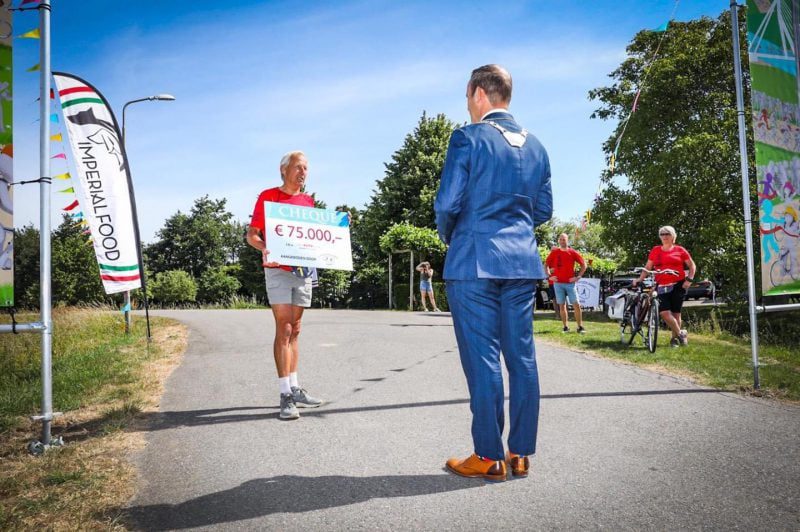 Bram van Hemmen neemt symbolisch cheque van 75 duizend euro van Roparunteam Hoeksche Waard Runners in ontvangst - Foto Gemeente Hoeksche Waard