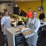 Op dinsdag 6 juli kreeg Kookstudio Hoeksche Waard onverwachts bezoek van Stichting SOB-HW (Samenwerking Onderwijs Bedrijfsleven Hoeksche Waard). De culinaire onderneming uit Numansdorp schreef zich onlangs als 150e bedrijf in op de website werkenenlerenindehoekschewaard.nl om jongeren een kans te bieden op beroepsoriëntatie in de horeca. Als dank ontvingen eigenaresse Michka Chel en haar team een smakelijke taart. - Foto Gemeente HW