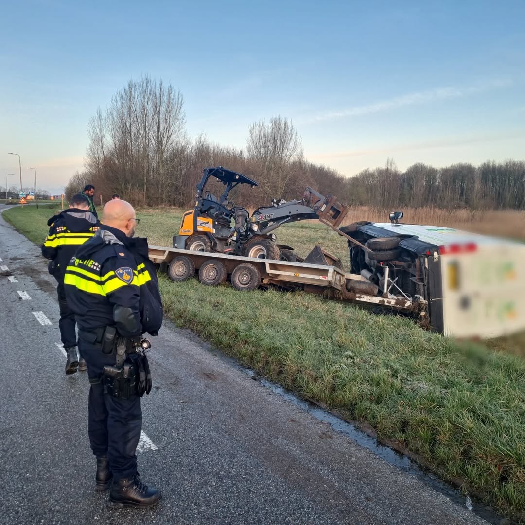 Bedrijfsbus met aanhanger van de weg door plaatselijke gladheid