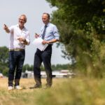 Wethouder Adriaan van der Wulp (rechts) en directeur-bestuurder Dennis Lausberg van HW Wonen (links) op locatie aan de Randweg in Oud-Beijerland, waar zij op vrijdag 18 juli hun handtekening zetten onder de afspraken voor de bouw van 21 tijdelijke woningen.