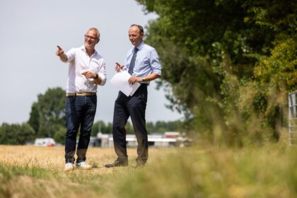 Wethouder Adriaan van der Wulp (rechts) en directeur-bestuurder Dennis Lausberg van HW Wonen (links) op locatie aan de Randweg in Oud-Beijerland, waar zij op vrijdag 18 juli hun handtekening zetten onder de afspraken voor de bouw van 21 tijdelijke woningen.