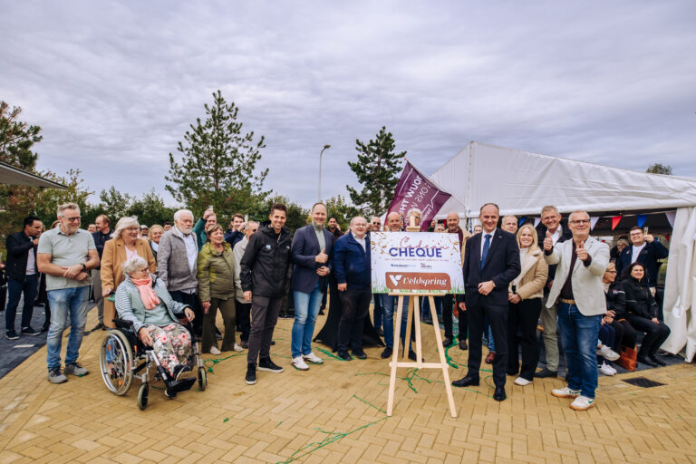 Bewoners, samen met vertegenwoordigers van gemeente Hoeksche Waard, HW Wonen en Zwaluwe Bouw, vieren de feestelijke oplevering van de nieuwe wijk De Veldspring in Strijen. Tijdens de bijeenkomst werd symbolisch een cheque overhandigd als cadeau aan de wijk.