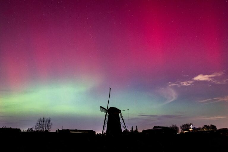 Het noorderlicht kleurt de nachtelijke hemel boven de Poldersche molen in Maasdam. Foto: Jeffrey Groeneweg.