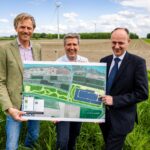 Van links naar rechts staan Jaap Rottink (rentmeester a.s.r. real assets), Ronald Kloet (ontwikkelaar Renewable Factory) en wethouder Adriaan van der Wulp aan de rand van het toekomstige gebied De Buitenzomerlanden bij Heinenoord. Zij tonen een impressie van de inrichting van het nieuwe energielandschap, dat bestaat uit natuurontwikkeling, zonne-energie en batterijopslag. Op de achtergrond zijn de windmolens van het bestaande windpark zichtbaar. Foto: Jeffrey Groeneweg.