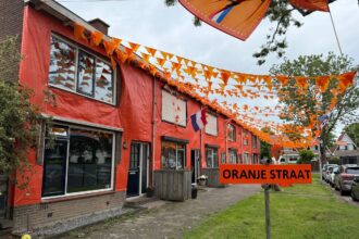 De bewoners van de Van der Merckstraat in ’s-Gravendeel hebben hun straat volledig in oranje WK-sferen gebracht met honderden meters vlaggetjes, oranje folie, spandoeken en een grote Oranje Leeuw als blikvanger. Foto: Van der Merckstraat ’s-Gravendeel.