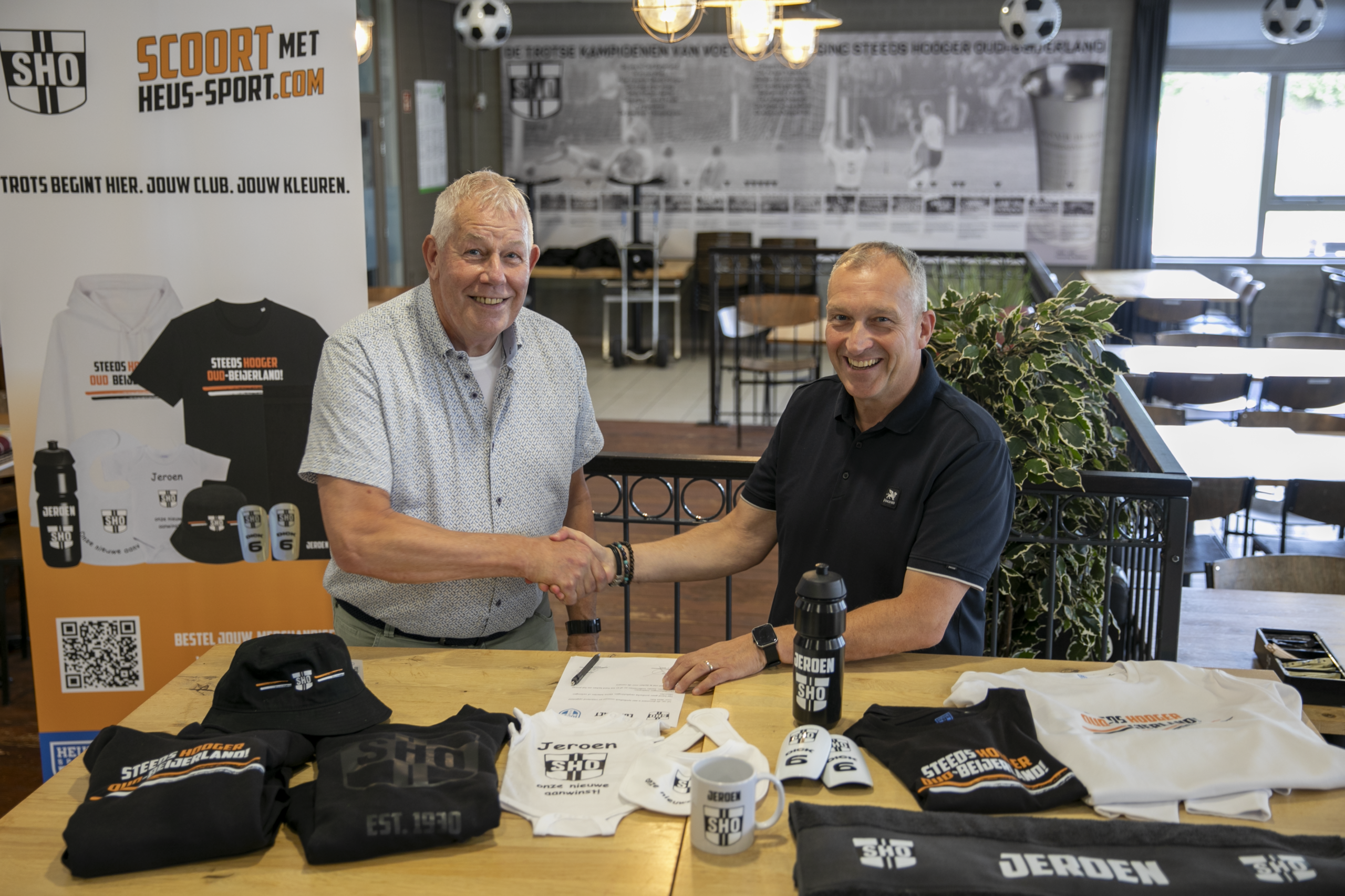 Ben de Kok (links) en Dick de Heus (rechts) schudden elkaar de hand na de ondertekening van de samenwerkingsovereenkomst.